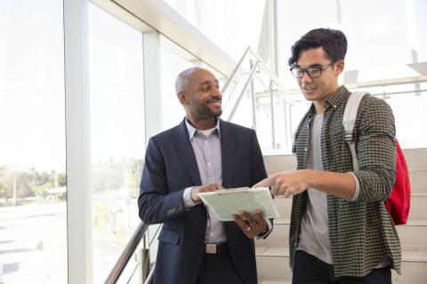 adult professional with student reviewing a letter